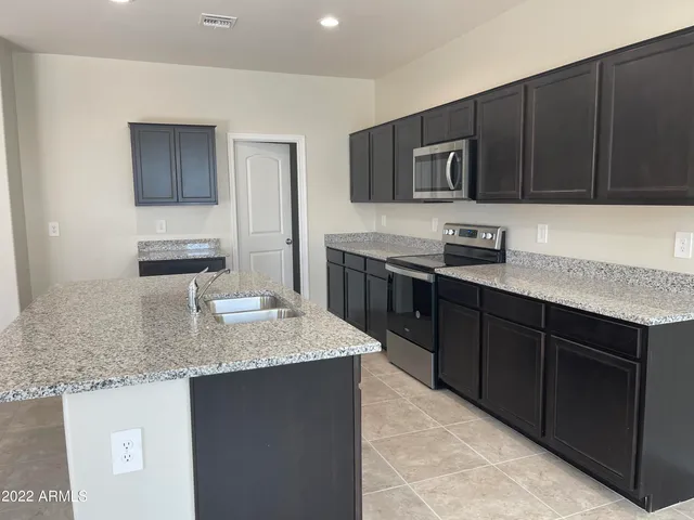 a kitchen with stainless steel appliances granite countertop a sink stove and microwave
