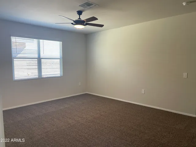 an empty room with a window and a fan