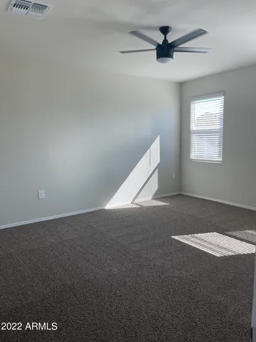 en empty room with windows and ceiling fan