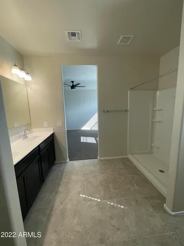 a spacious bathroom with a granite countertop sink a toilet and mirror