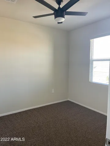 an empty room with a window and a fan