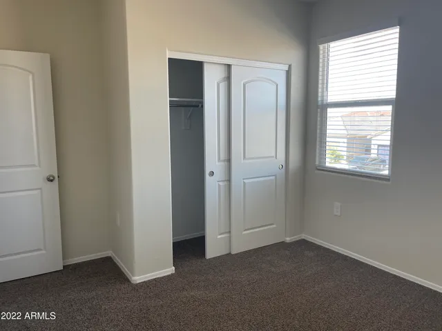 an empty room with windows and closet