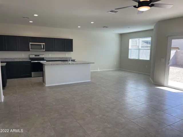 a kitchen with stainless steel appliances a stove top oven a sink a window and white cabinets