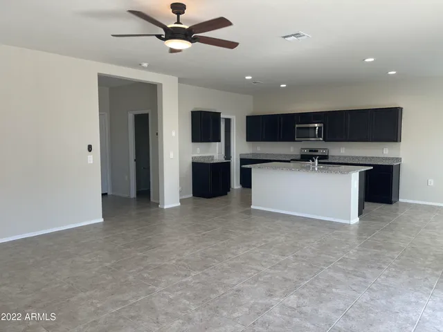 a view of kitchen with stainless steel appliances kitchen island a sink a stove and a refrigerator