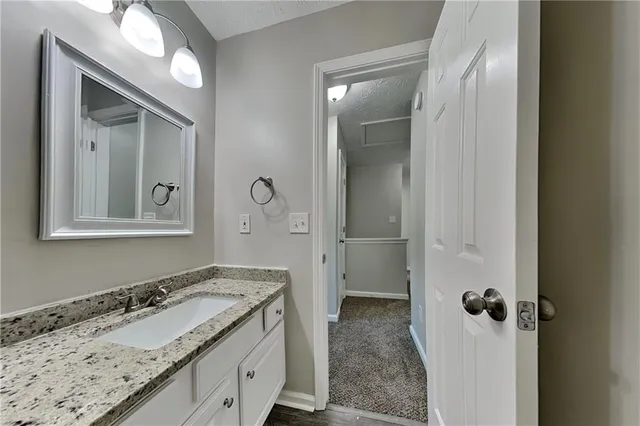 a bathroom with a granite countertop sink and a mirror