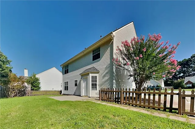 a backyard of a house with table and chairs