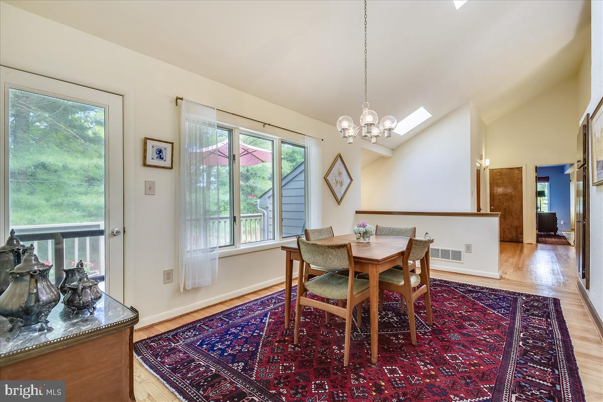 2224 Traceys Road Sparks, MD 21152 - Photo 22 of 53 a dining room with wooden floor a chandelier a wooden table and chairs