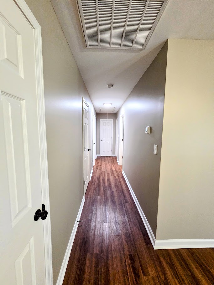 509 Elrod Road Piedmont, SC 29673 - Photo 16 of 28 Rich hardwood-style flooring extends through this central interior corridor, leading to multiple rooms.
