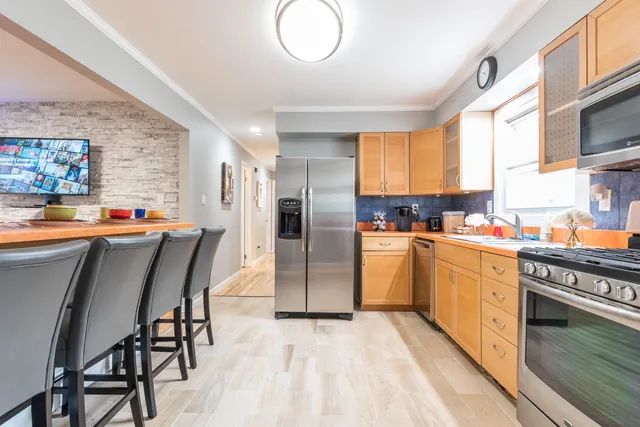a kitchen with stainless steel appliances granite countertop a refrigerator and a stove top oven