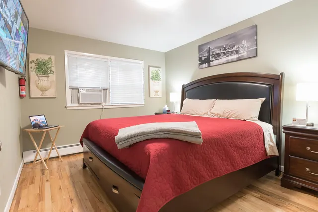 a bedroom with a bed and wooden floor