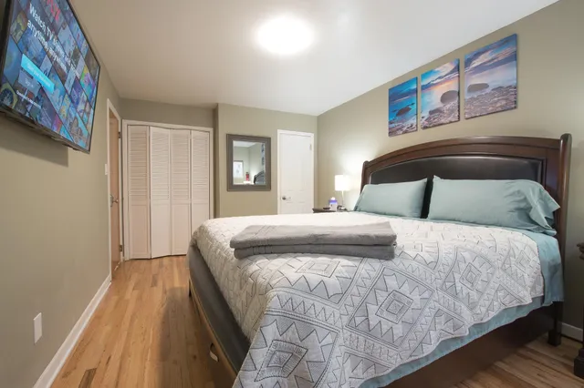 a bedroom with a bed and a painting on the wall