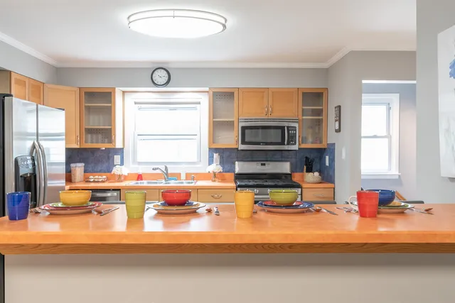 a living room with furniture kitchen view and a window