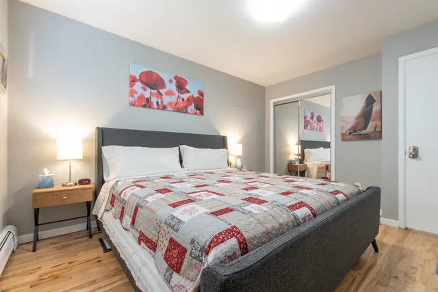 a bedroom with a bed and painting on the wall