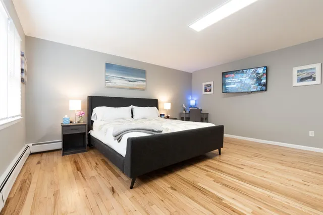 a spacious bedroom with a bed and a wooden floor