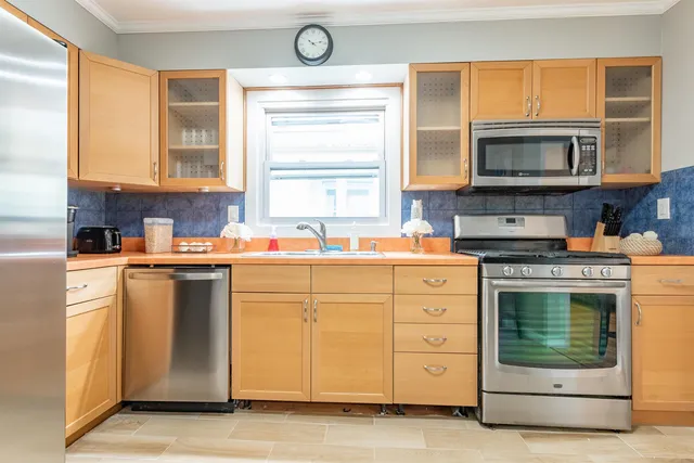 a kitchen with stainless steel appliances granite countertop a stove a sink and a microwave