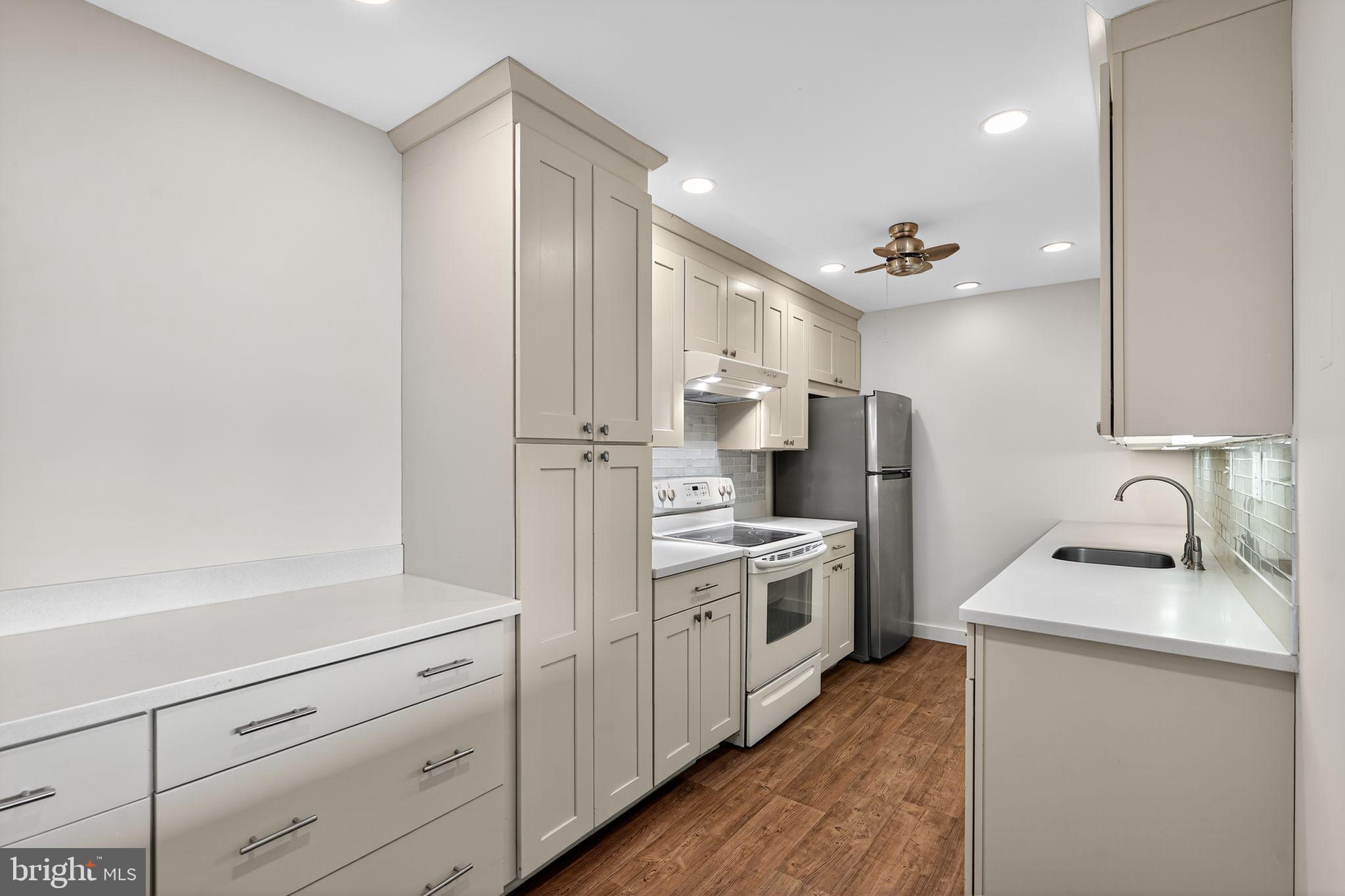 17 Haddonfield Cmns Haddonfield, NJ 08033 - Photo 10 of 37 a kitchen with white cabinets and stainless steel appliances