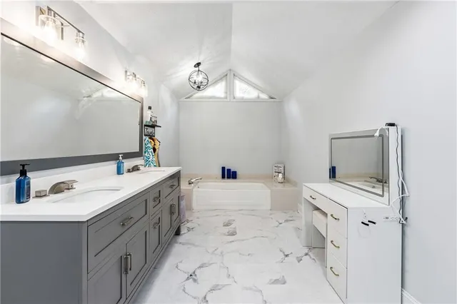 a bathroom with a double vanity sink mirror and bathtub