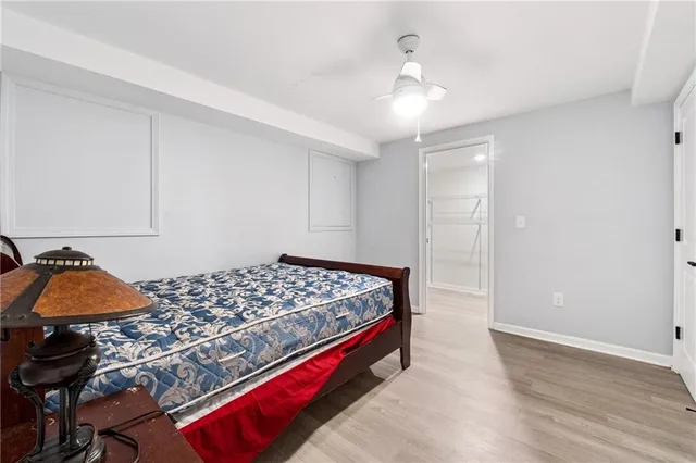 a bedroom with a bed and a lamp on dresser