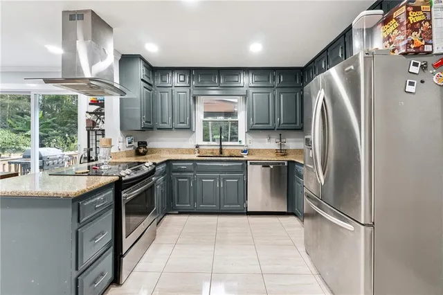 a kitchen with granite countertop a refrigerator stove top oven and sink