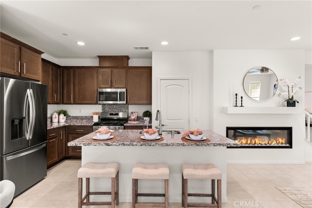 32461 Brunello Way Temecula, CA 92591 - Photo 13 of 46 a kitchen with kitchen island granite countertop a stove a sink a refrigerator cabinets and a dining table