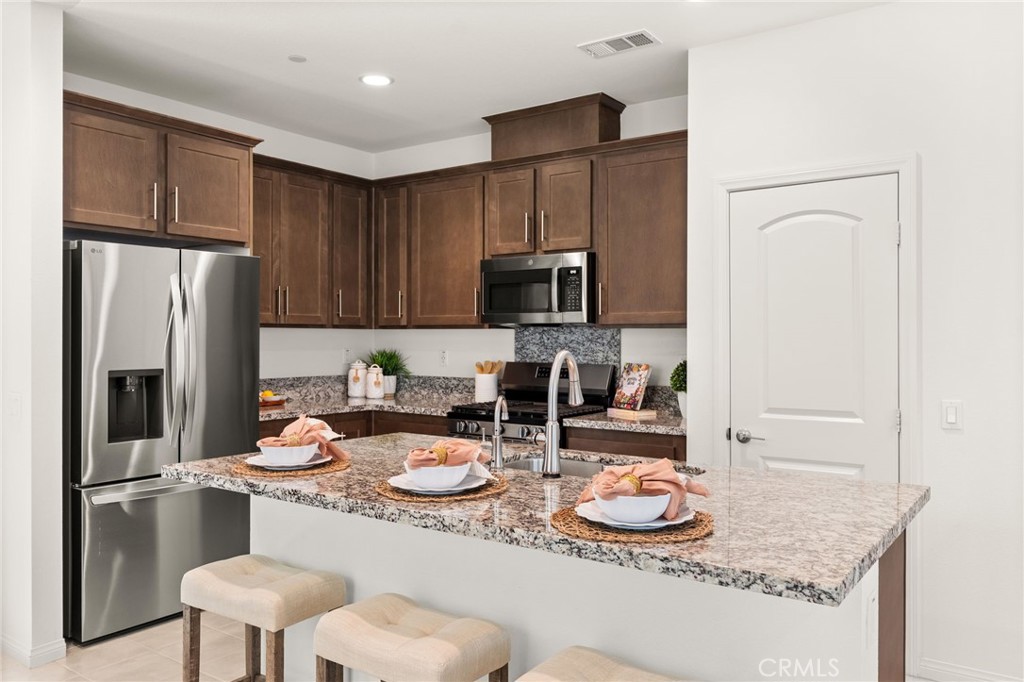 32461 Brunello Way Temecula, CA 92591 - Photo 14 of 46 a kitchen with stainless steel appliances granite countertop a sink a refrigerator and a stove