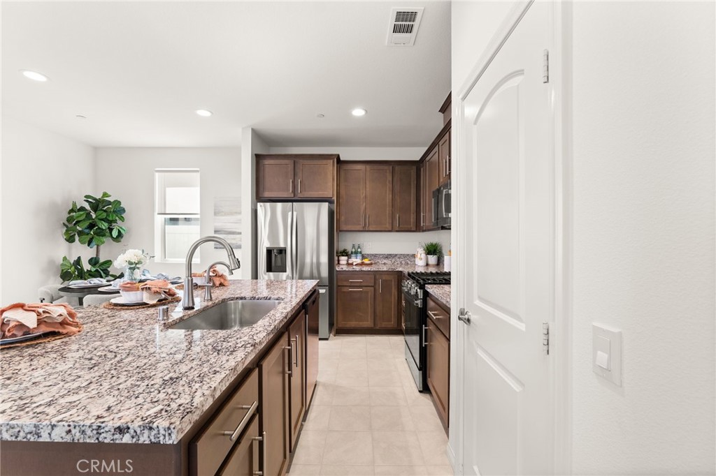 32461 Brunello Way Temecula, CA 92591 - Photo 15 of 46 a kitchen with stainless steel appliances granite countertop a sink stove and refrigerator