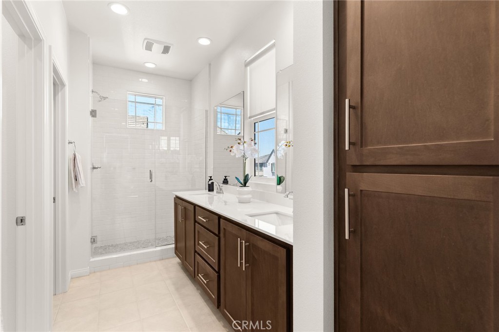 32461 Brunello Way Temecula, CA 92591 - Photo 20 of 46 a bathroom with a sink a mirror and a shower