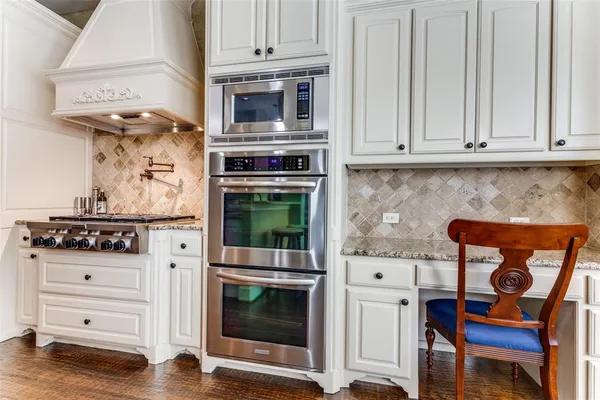 a kitchen with stainless steel appliances granite countertop a sink dishwasher and a stove with wooden floor