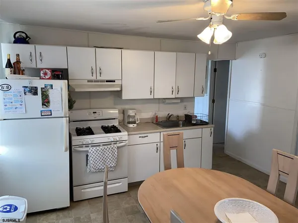 a kitchen with a white cabinets and white appliances