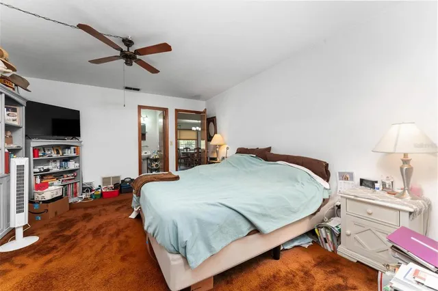 a view of a dining room and livingroom with furniture wooden floor a rug a painting and a chandelier