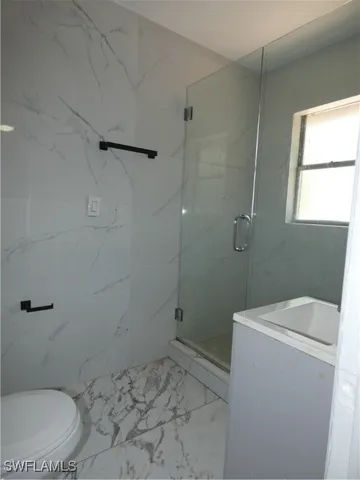 a bathroom with a granite countertop toilet and a sink