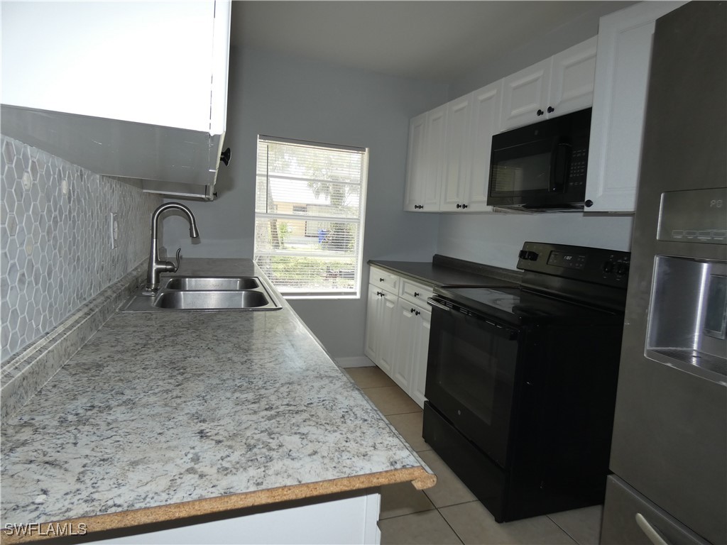3817 Pearl Street Fort Myers, FL 33916 - Photo 7 of 21 a kitchen with granite countertop a sink and a stove top oven