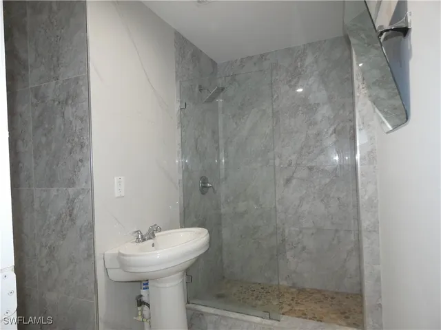 a bathroom with a sink mirror toilet and shower