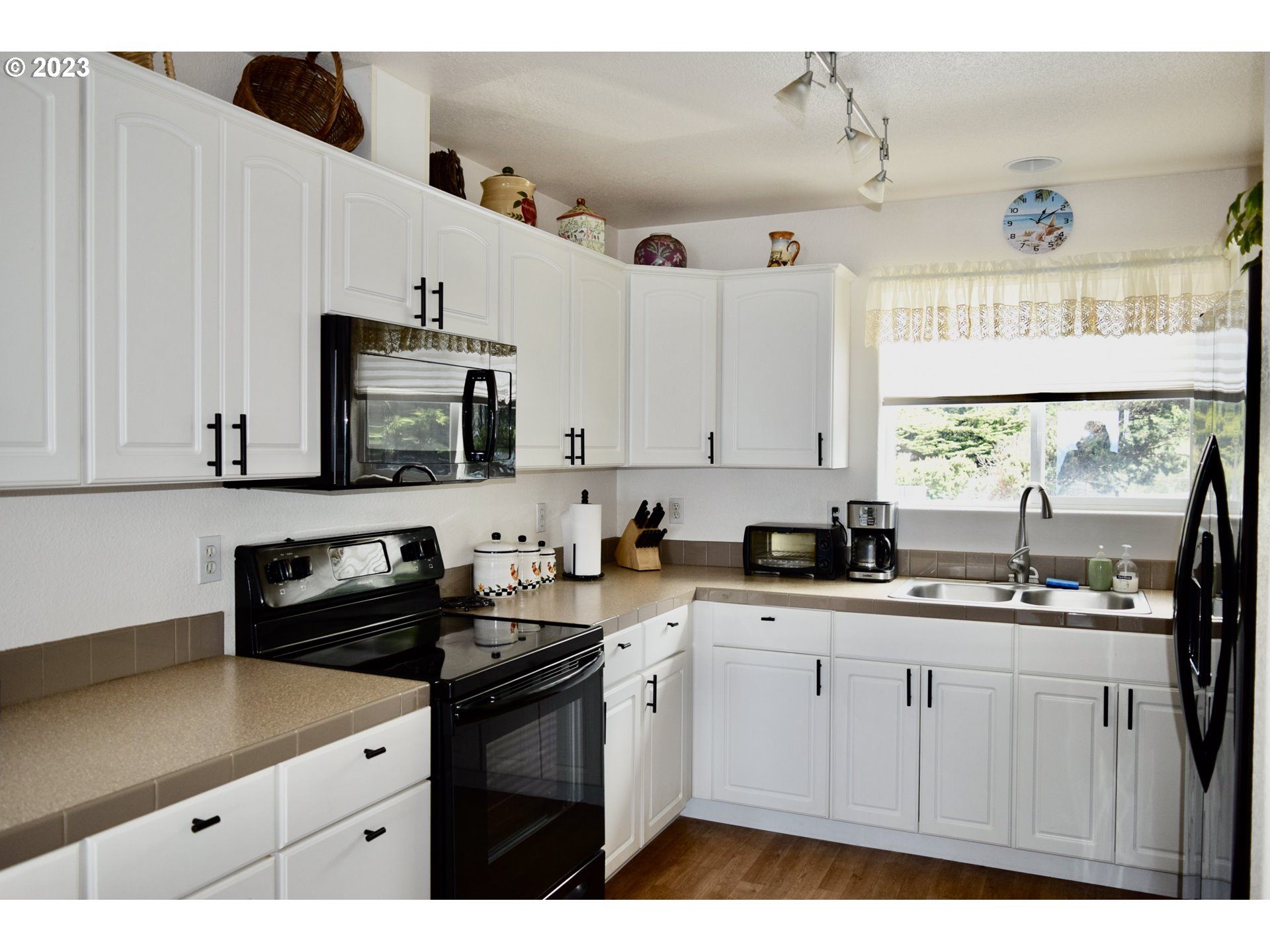 33074 Nesika Road Gold Beach, OR 97444 - Photo 16 of 40 a kitchen with a sink window and cabinets