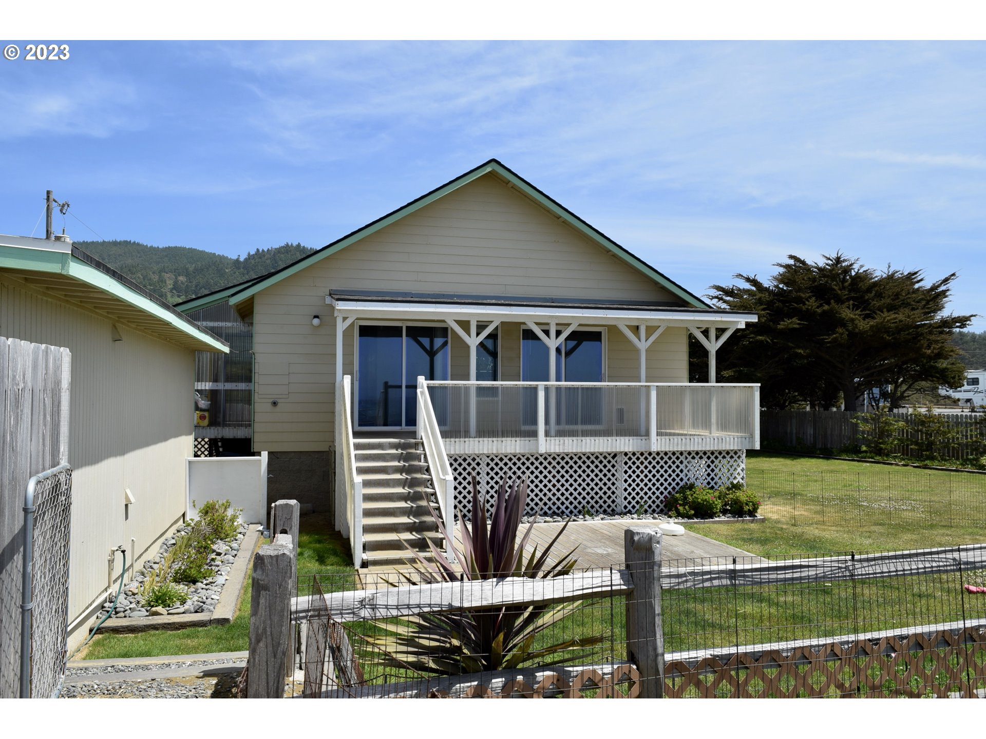 33074 Nesika Road Gold Beach, OR 97444 - Photo 2 of 40 a front view of a house with a yard