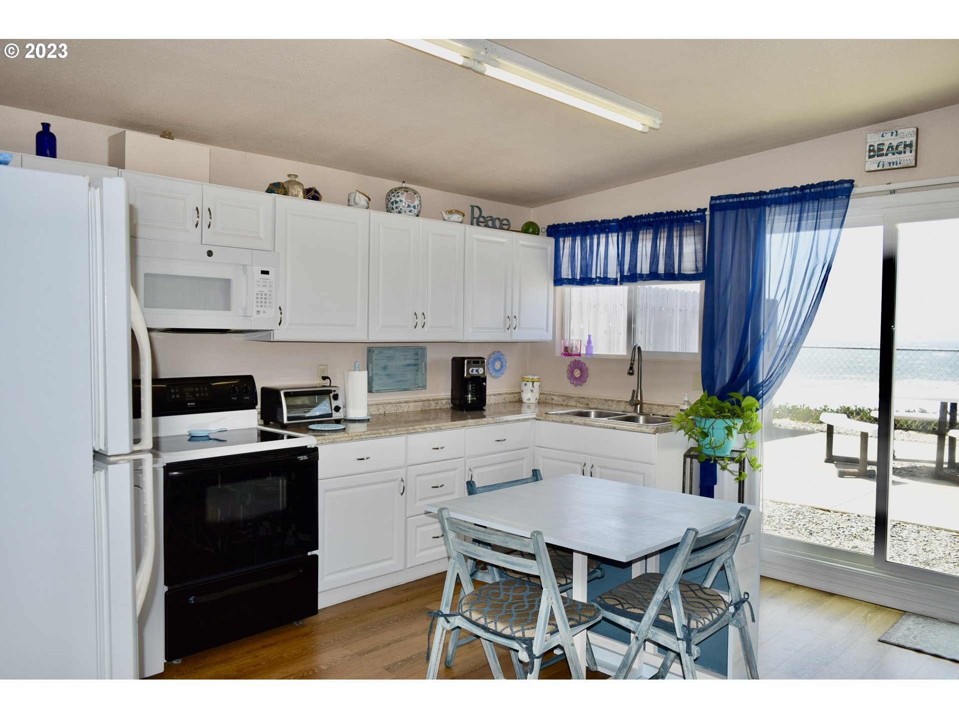 33074 Nesika Road Gold Beach, OR 97444 - Photo 32 of 40 a kitchen with a stove a refrigerator and a dining table