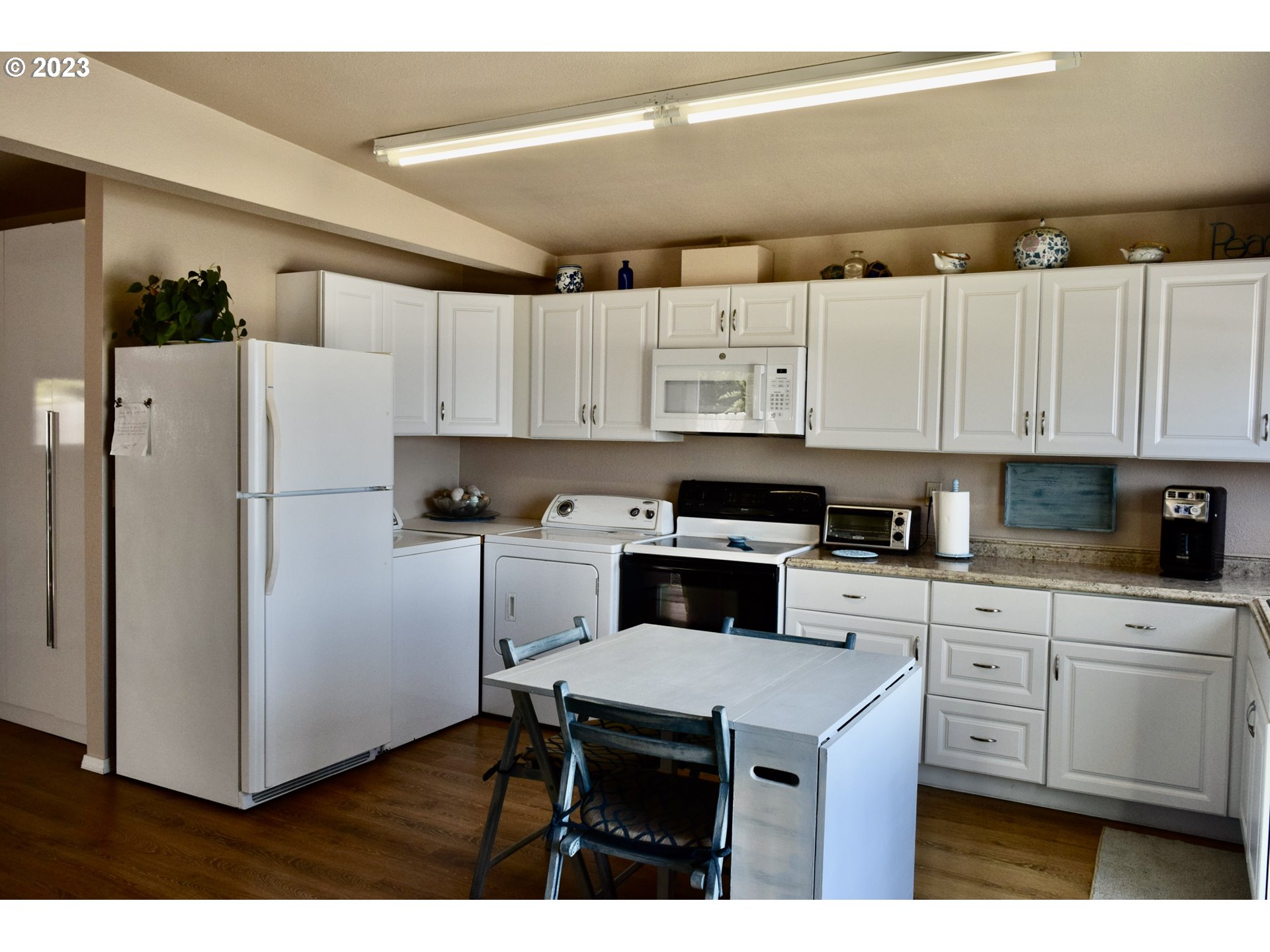 33074 Nesika Road Gold Beach, OR 97444 - Photo 33 of 40 a kitchen with stainless steel appliances a refrigerator a stove a sink and white cabinets