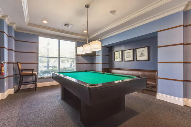 a room with pool table and windows