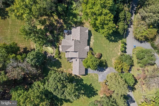 an aerial view of residential house with outdoor space and trees all around