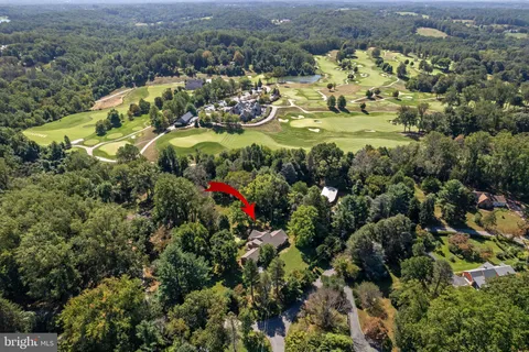 an aerial view of residential house with outdoor space and trees all around