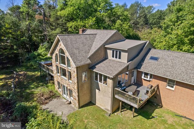 an aerial view of a house with a yard lake and trees all around