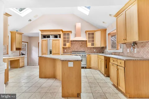 a large kitchen with granite countertop a sink a counter top space and cabinets
