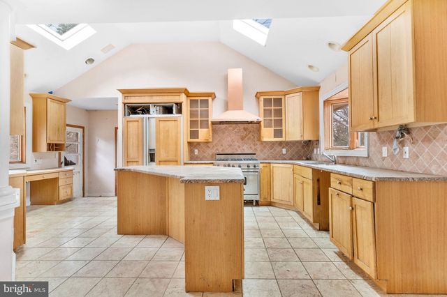 a large kitchen with granite countertop a sink a counter top space and cabinets