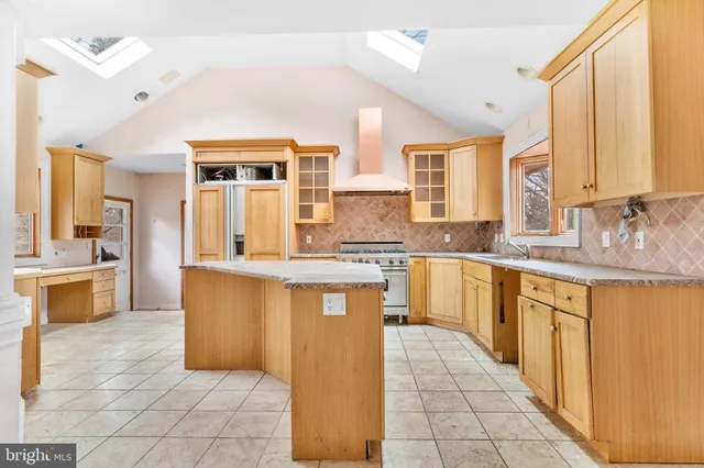 a large kitchen with granite countertop a sink a counter top space and cabinets