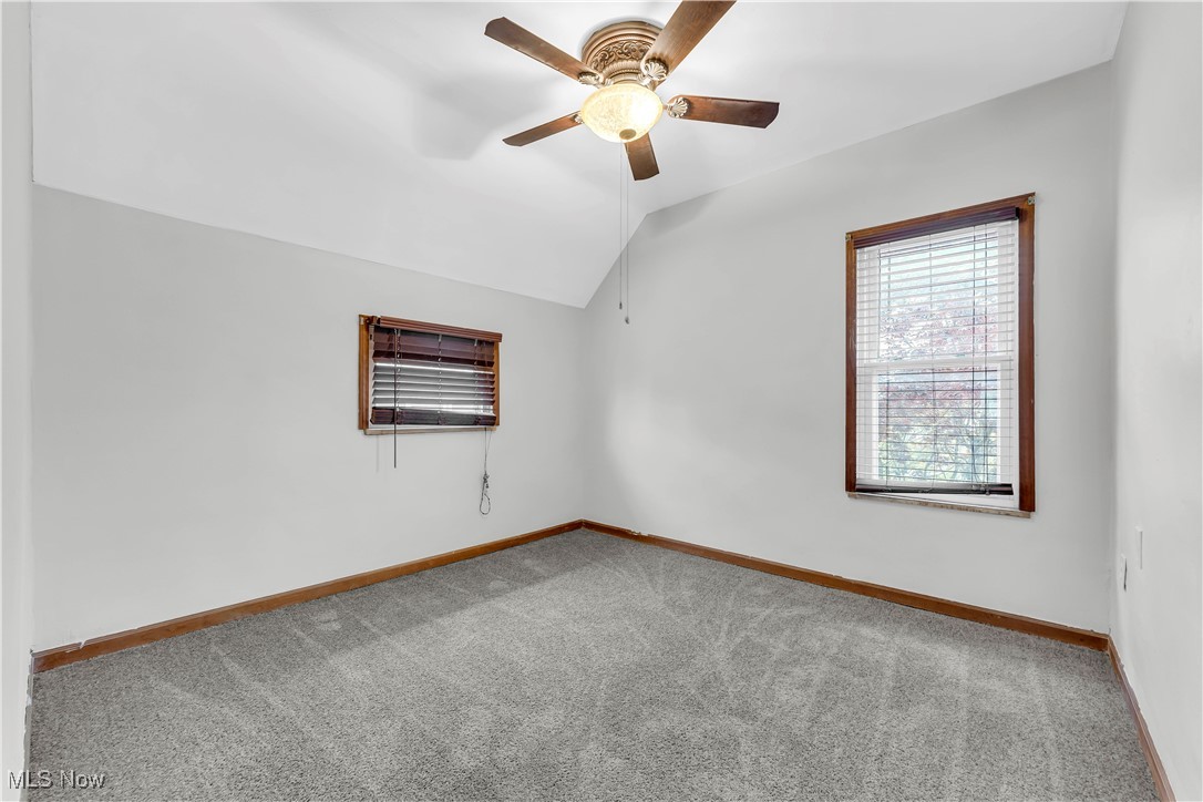 3374 Fulton Road Cleveland, OH 44109 - Photo 15 of 27 Carpeted empty room featuring vaulted ceiling and a ceiling fan