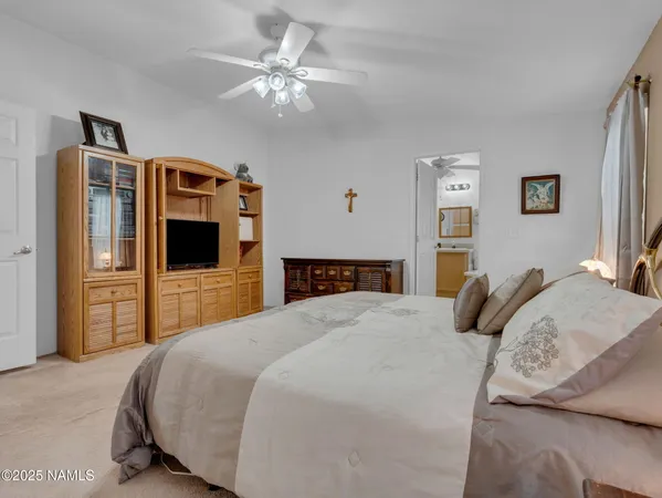 a bedroom with a large bed a flat tv screen and dresser