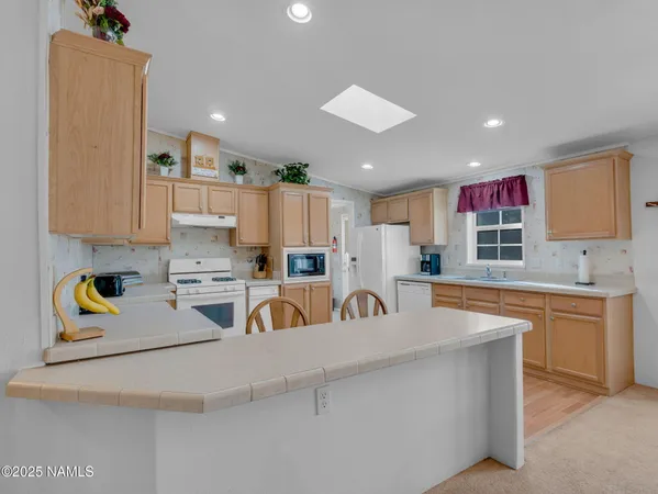 a kitchen with kitchen island a sink a stove and cabinets