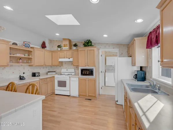 a kitchen with stainless steel appliances granite countertop a refrigerator sink and stove