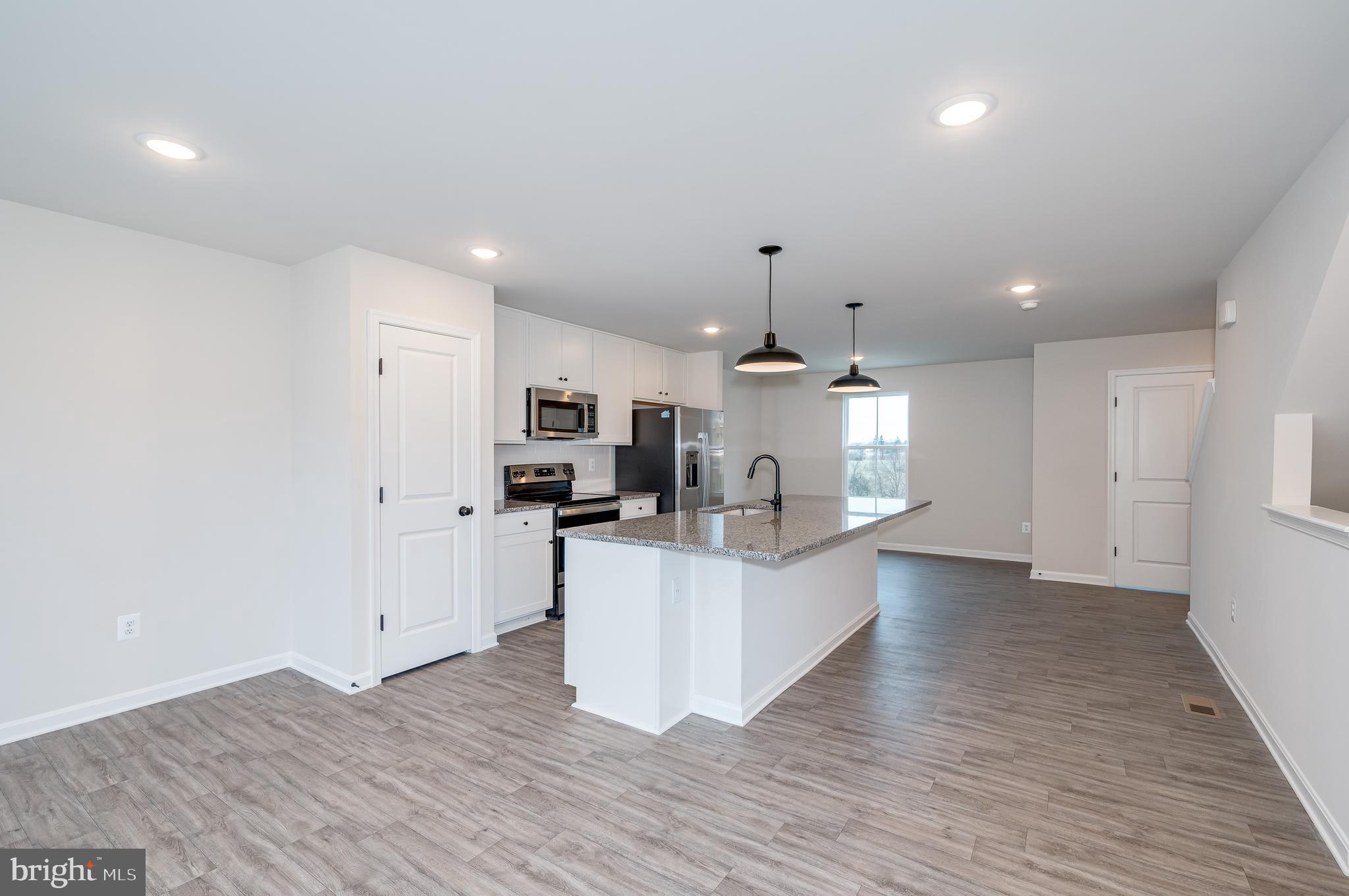 164 Rabbit Road Hedgesville, WV 25427 - Photo 22 of 41 a kitchen with stainless steel appliances kitchen island wooden floors granite counter tops and a view of living room