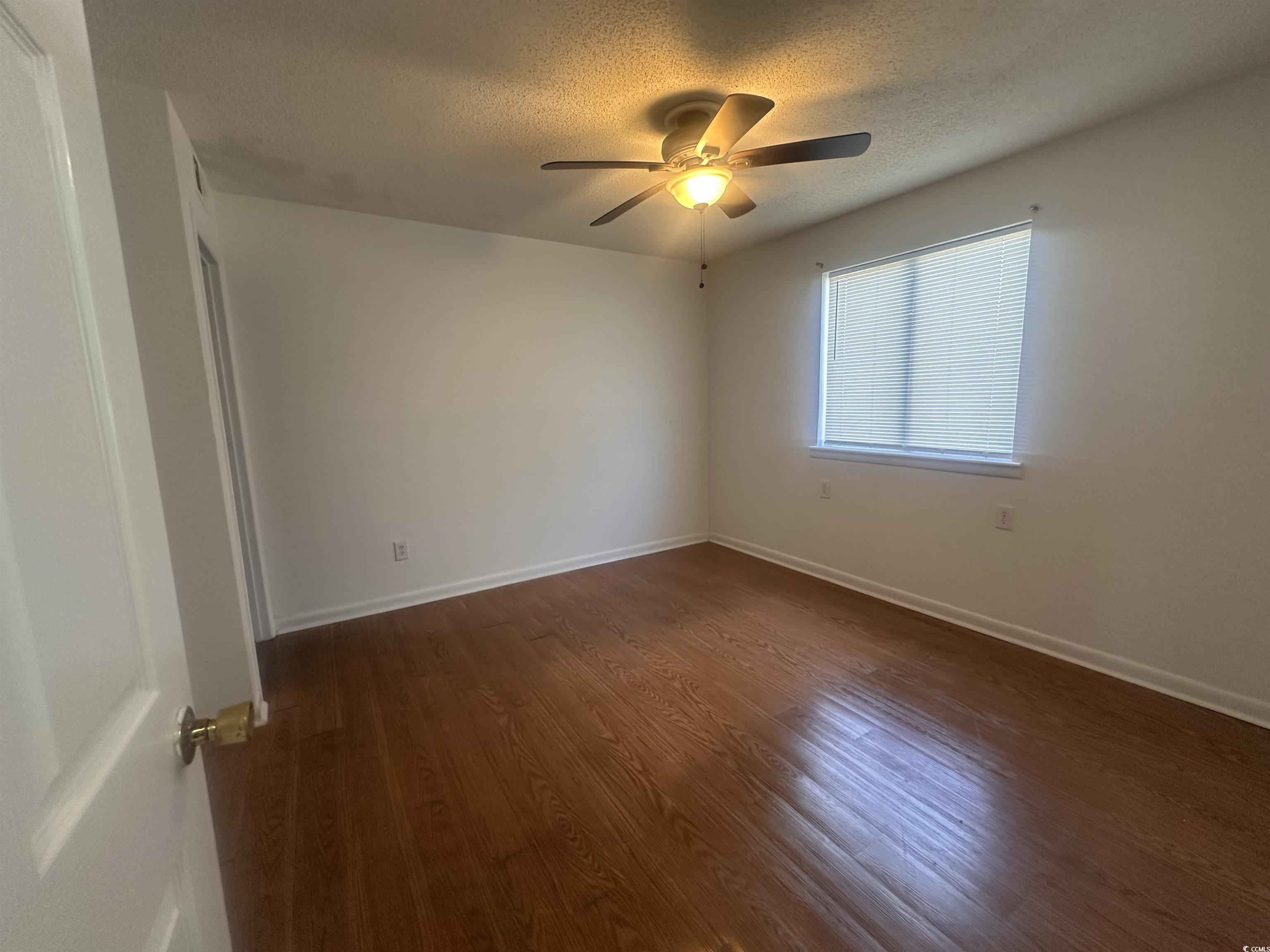 3555 Highway 544, Unit 27B Conway, SC 29526 - Photo 2 of 6 Unfurnished room with dark wood finished floors, a textured ceiling, and a ceiling fan